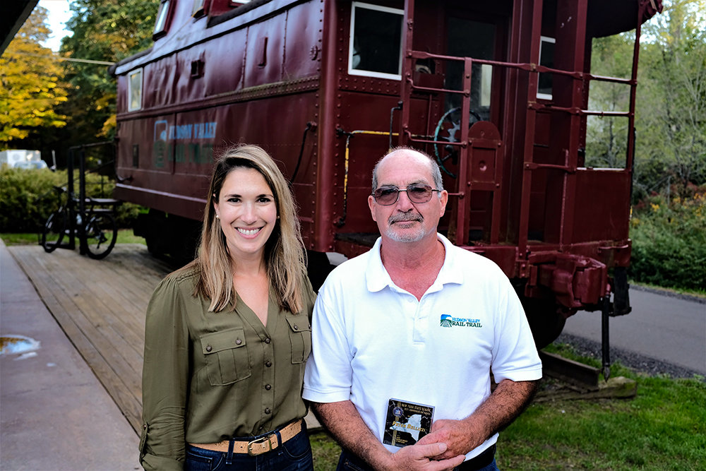Sen. Michelle Hinchey [D-46] and Hudson Valley Rail Trail Association President Peter Bellizzi stand beside a caboose at the trail-head. Hinchey presented Bellizzi with a NYS Commendation for his commitment and selfless service to the Rail Trail.